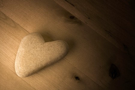 Heart shaped Stone on wooden Table in background.の写真素材