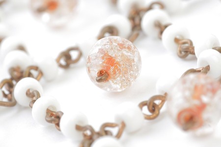Fragment of Coppery Necklace with Beads in White Orange and Reflected. White background.の写真素材