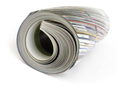 Color magazine rolled up on the white background. Close-up. Isolated.の写真素材