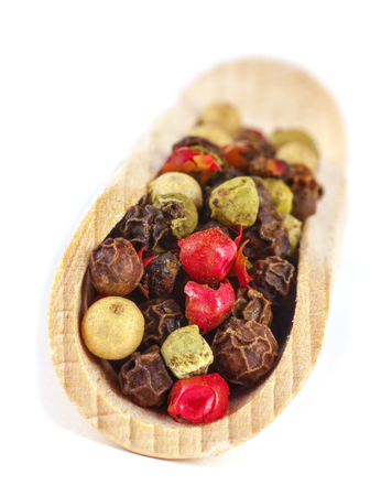 Color dryed Pepper on wooden spoon, isolated over White Background.の写真素材
