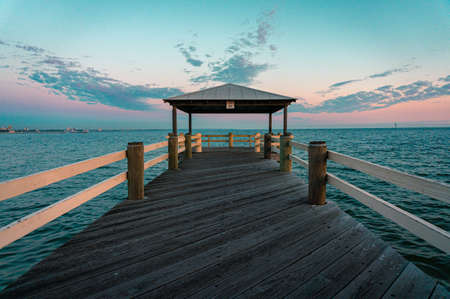 Wooden pier with a pavilion on the sea at sunset.の写真素材