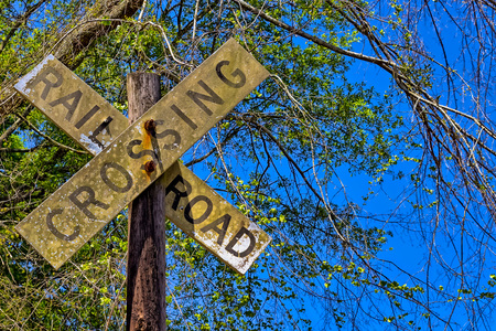 Dirty rail road crossing sign on wooden  postの写真素材