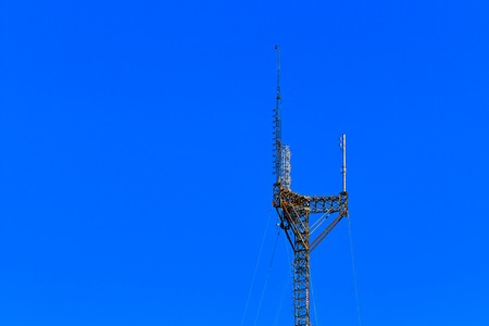 Tall, large, cell phone tower against a blue  skyの写真素材