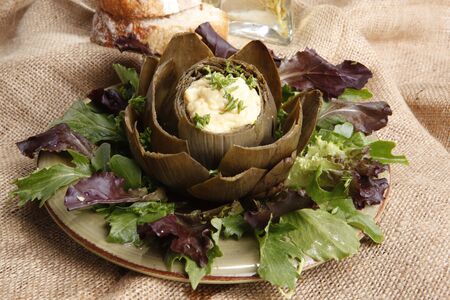 Steamed Artichoke stuffed with Hollandaise sauceの写真素材