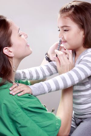 Preteen gets a swine flu shot from her doctorの写真素材