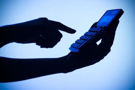 isolated on blue silhouette of woman's hands with calculatorの写真素材