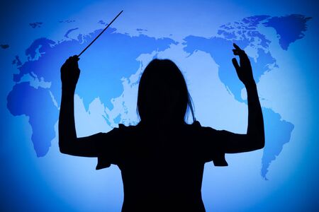 silhouette of female conductor on the blue world mapの写真素材