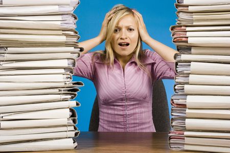 overworked young blonde woman at the office desk
