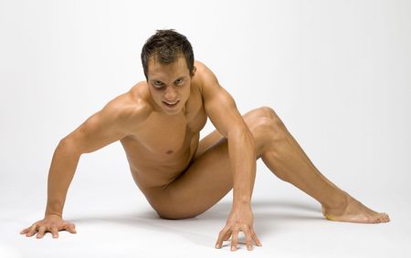 Young and muscular man sitting. He's face looks wild.の写真素材