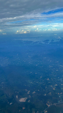 Aerial view of clouds in the blue sky above the ground.