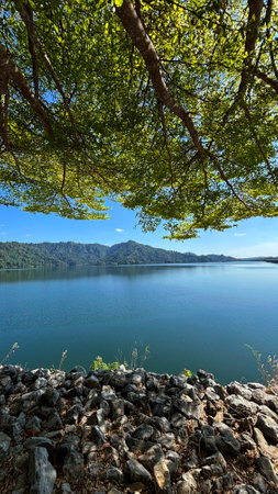 Lake view with trees and blue sky in the morning, Khun Dan Prakarnchon Dam Reservoir and Scenic View in Nakhon Nayok, Thailandの写真素材