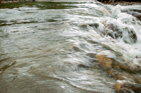 Waterfall flowing over rocks in a stream in Nakhon Si Thammarat, Thailand, closeup of photo