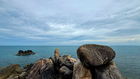 Rocky coast of the sea under a cloudy sky, Hin Ta Hin Yai Rock Formations in Koh Samui, Thailandの写真素材