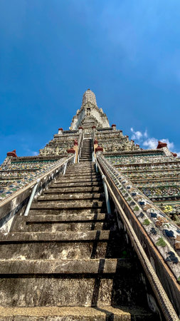 Stairs leading to Wat Arun temple in Bangkok Thailand with blue skyの写真素材
