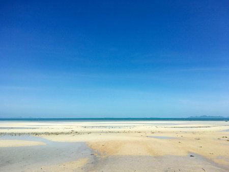 Tropical beach at low tide with white sand and blue sky in Koh Samui, Thailandの写真素材
