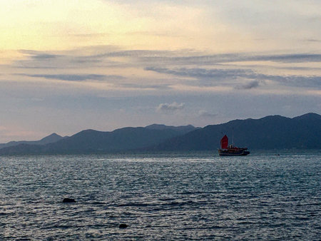 Boat in the sea on the background of mountains at sunset at Koh Samui, Thailandの写真素材