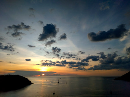 Beautiful sunset over the sea. Sunset on the sea. The sun sets behind the clouds from Windmill Viewpoint in Phuket, Thailandの写真素材