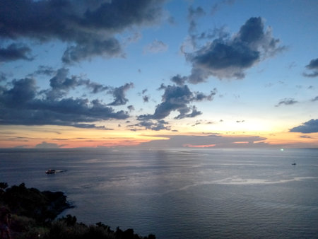 Sunset at the seaside at windmill viewpoint in Phuket, Thailandの写真素材