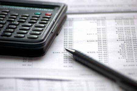 characteristic accounting paperwork with data files and black penの写真素材