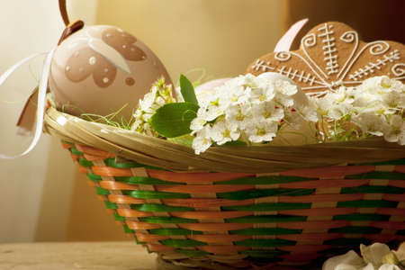 basket with colored eggs, flowers and gingerbreadの写真素材