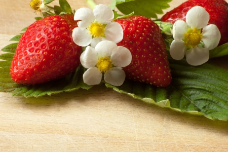 fresh red strawberries with leaves and flowersの写真素材