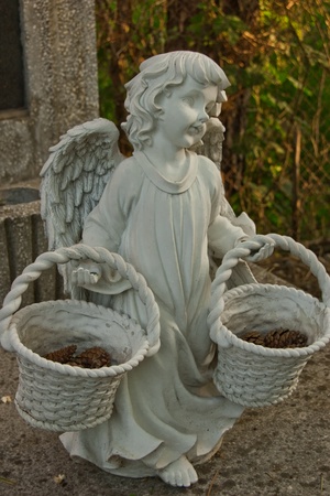 gray angel statue tombstone with two basketsの写真素材
