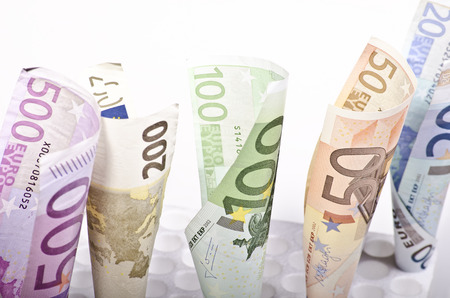 European banknotes of different value rolled on white backgroundの写真素材