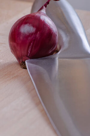 sharp kitchen instruments represented by metallic knives and fresh vegetablesの写真素材