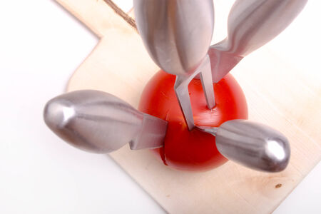 sharp kitchen instruments represented by metallic knives and fresh vegetablesの写真素材