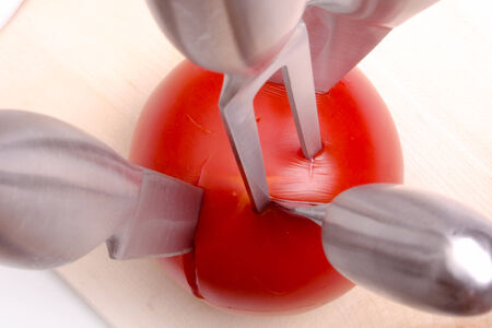 sharp kitchen instruments represented by metallic knives and fresh vegetablesの写真素材