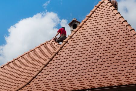 roofing worker on the house during daylightの写真素材