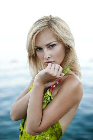 fashionable blonde women in beautiful green dress near seaの写真素材