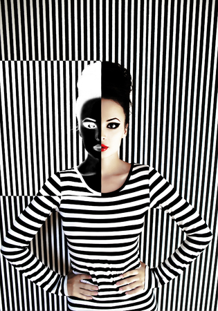 fashion woman in striped dress on striped background in studioの写真素材