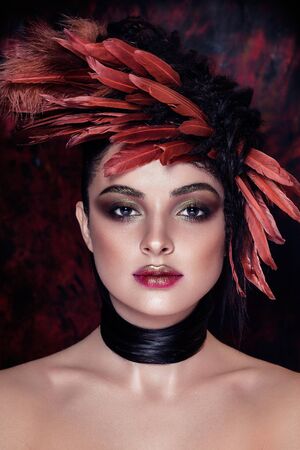 Fashion model. Red Colors. Art background. Styling hair with featherの写真素材