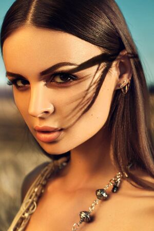 Summer portrait, young brunette woman posing outdoor in golden fieldsの写真素材