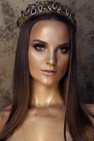 Beauty Fashion model girl with Golden Makeup, on golden background. glance Fashion art portrait, Hairstyle and make upの写真素材