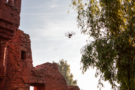 The drone with the professional camera takes pictures. Uav drone copter flying with digital camera. Hexacopter drone with high resolution digital camera on the sky.の写真素材