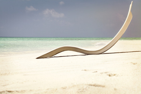 white sunbed on tropical calm beach with turquoise caribbean sea water and white sand
