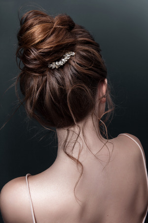 Model brunett Woman with perfect hairstyle and creative hair-dress, back view.の写真素材