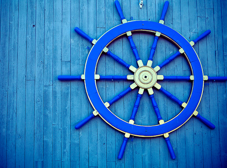 Old Vintage Blue Wooden Helm Wheel on the wall.の写真素材