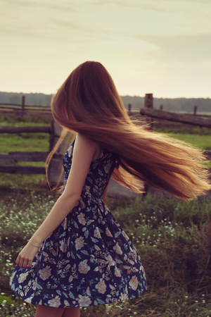 romantic style long hair girl in sunset light outdoor portrait.の写真素材