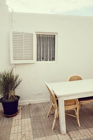 white house with white open window and white table in front in the yard, Ibiza.の写真素材