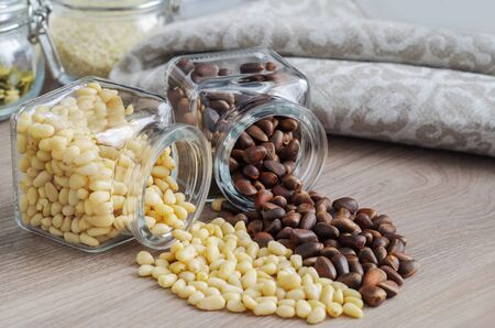 Pine nuts are peeled and unpeeled together in a heart shape scattered from the jarsの写真素材