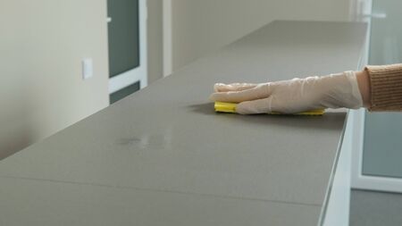 Sanitizing and disinfecting surfaces with yellow rag against coronavirus and bacteria.の写真素材