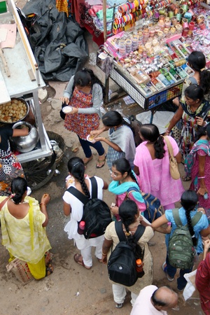Hyderabad,AP,India-August 9,2011-Group of indian girl students eating street food in a busy market.