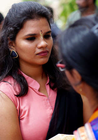 HYDERABAD,INDIA-AUGUST 24,2019: Indian Hindu woman apply Tilak on fore head of a devotee,a religious ritual,on Krisnastami festival celebration in God Krishna templeのeditorial素材