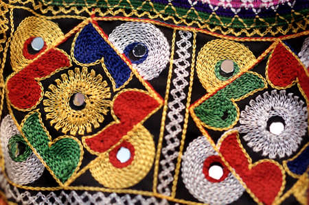 Close-up view of Indian traditional needle work on cloth with glass piecesの写真素材