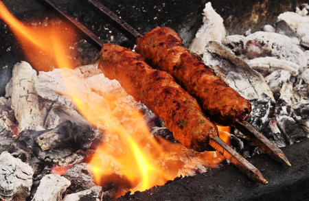 Close-up view of making mutton kababs or kebabs on coal fired arrangementの写真素材