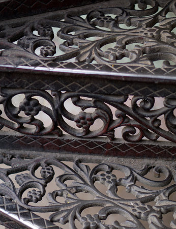Close-up view of metal spiral stair case steps with floral designの写真素材
