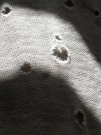 Close-up view of textile material and texture with holes in sunlight